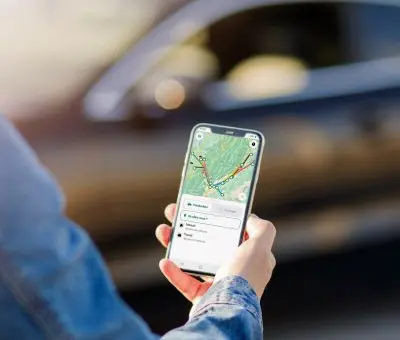 Utilisateur de l'application Ecov sur smartphone, planifiant un trajet de covoiturage